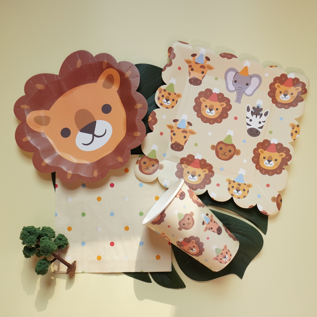 Party supplies with lion plate,  lion design on plates, cups, and napkins against a light background