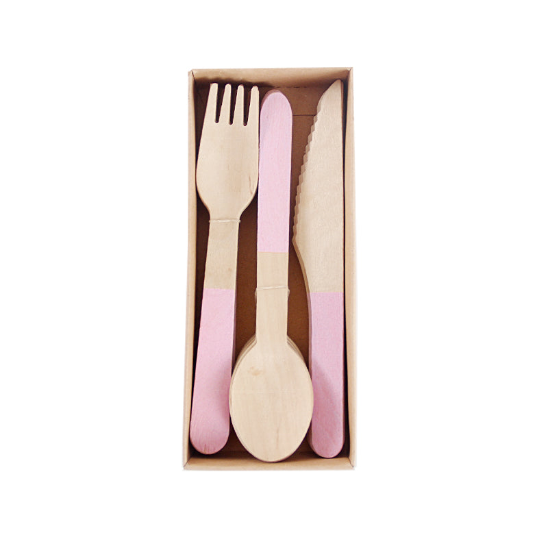 Set of wooden cutlery including a fork, knife, and spoon with pink handles in a box on a white background.